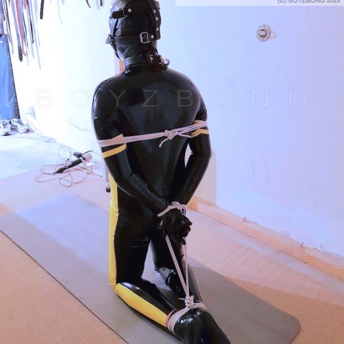 rubber gimp waiting his hogtie and spanking punishment